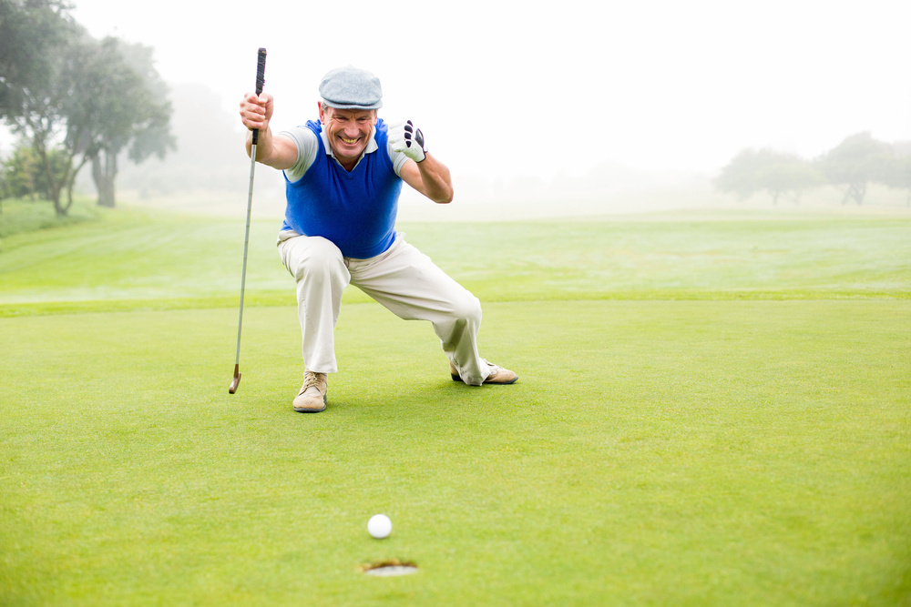 Happy golfer cheering on putting green on a foggy day at the golf course Happy golfer cheering on putting green on a foggy day at the golf course